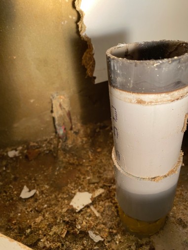Maintenance work. JMT Plumbing carves away kitchen cabinetry to reveal the source of a hidden leak.